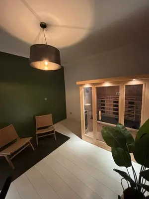 a living room with a table and chairs and a lamp at Vakantiewoning Huis 14 in Mechelen