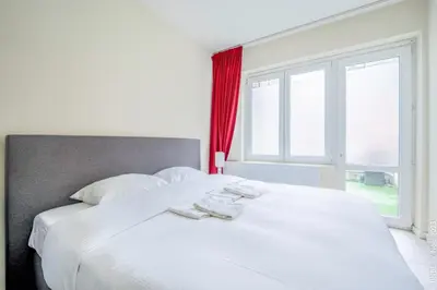 a large white bed in a room with a window at Center of Antwerp - Fully Renovated - Private Indoor Parking in Antwerp