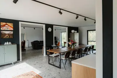 a dining room and living room with a table and chairs at De Logé in Oud-Turnhout