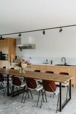 a kitchen with a large wooden table with chairs at De Logé in Oud-Turnhout