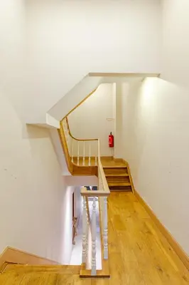 a spiral staircase in a white room with wooden floors at Le Joyau à Etterbeek in Brussels