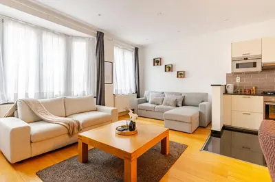 a living room with two couches and a coffee table at Le Joyau à Etterbeek in Brussels
