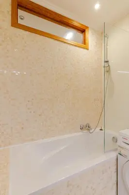 a bathroom with a tub and a glass shower at Le Joyau à Etterbeek in Brussels