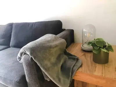 a blanket on a table next to a couch at Chère Anna City Center New Top location in Ghent