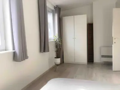 a white bedroom with a bed and a window at Chère Anna City Center New Top location in Ghent
