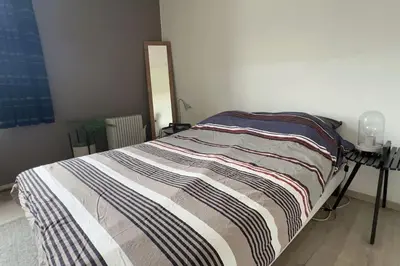 a bed with a striped blanket on it in a room at Chère Anna City Center New Top location in Ghent