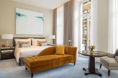 a bedroom with a bed and a couch and a table at Corinthia Grand Hotel Astoria Brussels in Brussels