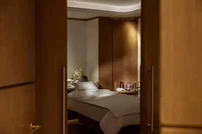 a bedroom with a bed and a wooden door with at Corinthia Grand Hotel Astoria Brussels in Brussels