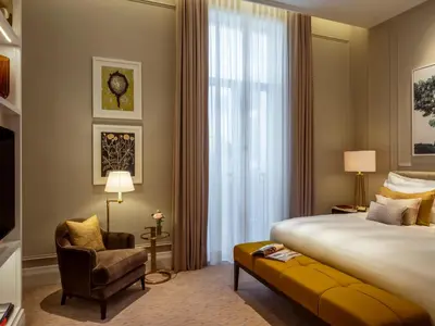 a hotel room with a bed and a chair at Corinthia Grand Hotel Astoria Brussels in Brussels