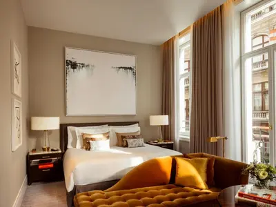 a bedroom with a large bed and a couch at Corinthia Grand Hotel Astoria Brussels in Brussels