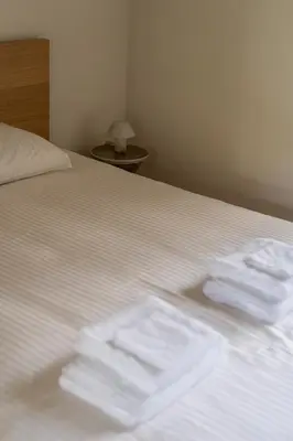 a bed with white sheets and folded towels on it at Moneta in Antwerp