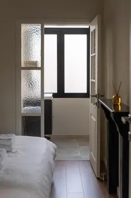 a bedroom with a bed and a large window at Moneta in Antwerp