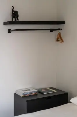 a bedroom with a black shelf above a bed at Moneta in Antwerp