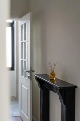 a black console table in a hallway with a door at Moneta in Antwerp