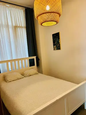 a bedroom with a bed with a window and a chandelier at Sublime appartement au centre de Bruxelles in Brussels