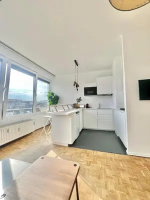 a kitchen with white cabinets and a large window at Petit cocon à Ixelles - Quartier Européen in Brussels