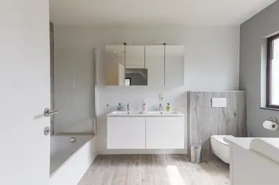a white bathroom with a sink and a shower at Villa Remis in Sint-Denijs-Westrem