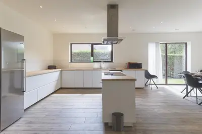 a kitchen with white cabinets and a counter top at Villa Remis in Sint-Denijs-Westrem