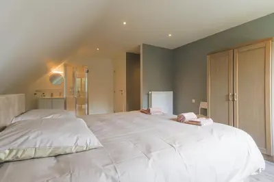 a bedroom with a large white bed in a room at Villa Remis in Sint-Denijs-Westrem