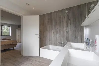 a white bathroom with a tub and a shower at Villa Remis in Sint-Denijs-Westrem