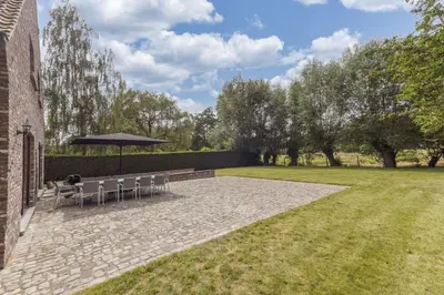 a patio with a table and an umbrella at Villa Remis in Sint-Denijs-Westrem