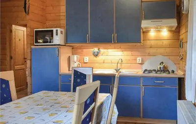 a kitchen with blue cabinets and a table and a microwave at Ranchero in Wachtebeke