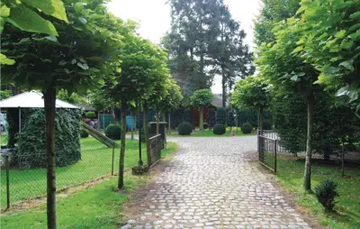 a cobblestone walk way in a park with trees at Ranchero in Wachtebeke