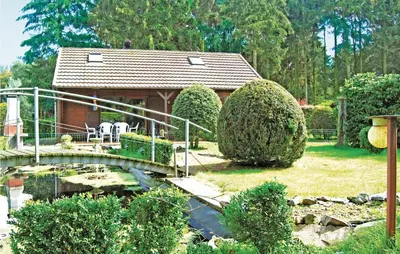 a house with a bridge over a pond in a yard at Groene Vallei in Wachtebeke