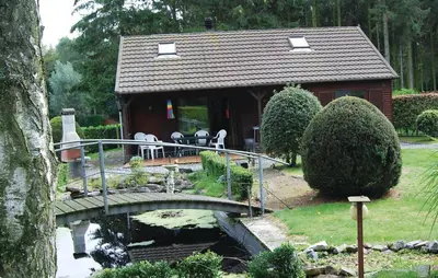 a small house with a bridge over a pond at Groene Vallei in Wachtebeke