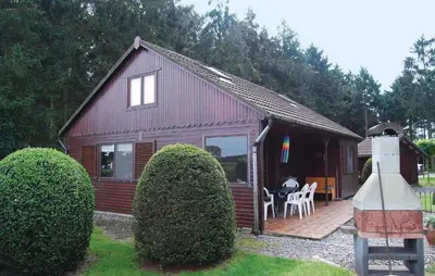 a small house with a deck and a table and chairs at Groene Vallei in Wachtebeke
