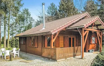 a wooden cabin with a porch and white chairs at Sjapoo in Wachtebeke