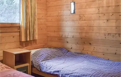 a bedroom with a bed in a wooden wall at Sjapoo in Wachtebeke
