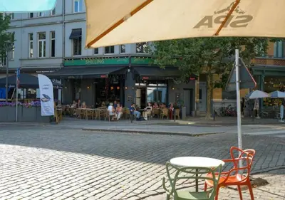 a table and chairs under an umbrella on a street at Elegant Escape in hartje Zuid in Antwerp
