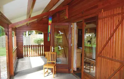 a wooden house with a porch with a wooden door at Flamenco in Wachtebeke