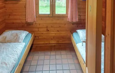 a room with two beds in a log cabin at Flamenco in Wachtebeke