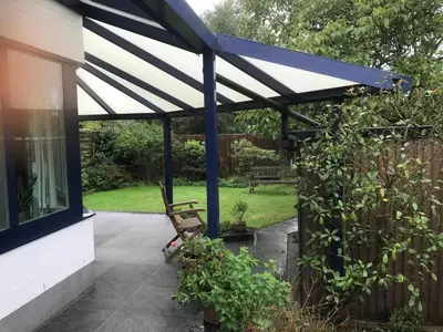 a patio with a blue and white awning at Twisted Willow in Dendermonde