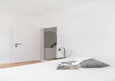 a white room with a mirror and a bed at Charming house in city center in Antwerp