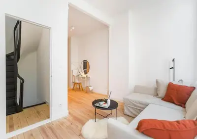 a white living room with a white couch and a table at Charming house in city center in Antwerp
