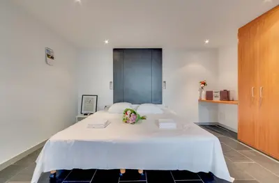 a bedroom with a large white bed with flowers on it at Grand Place Charbon Residence in Brussels