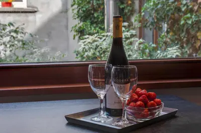 a bottle of wine and two glasses on a table at Grand Place Charbon Residence in Brussels