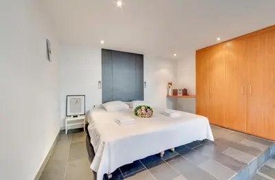 a bedroom with a large white bed with flowers on it at Grand Place Charbon Residence in Brussels
