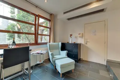 a room with a chair and a desk and window at Grand Place Charbon Residence in Brussels