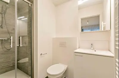 a white bathroom with a toilet and a shower at Beautiful apartment in City Center in Brussels
