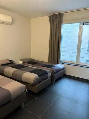 a hotel room with two beds and a window at Beautiful apartment in City Center in Brussels