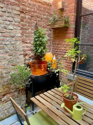 a patio with a bench and a table with potted plants at Art Studio Leuven in Leuven