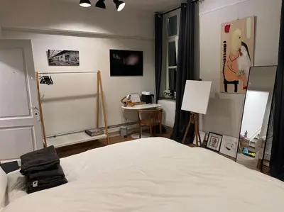 a bedroom with a white bed and a desk and a sink at Art Studio Leuven in Leuven