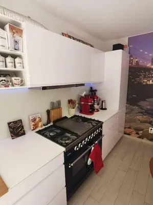 a kitchen with a stove and white cabinets at Rustige ruime duplex in Wijnegem