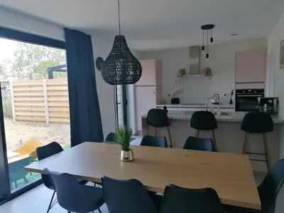 a dining room with a table and chairs and a kitchen at Dunehill in Balen