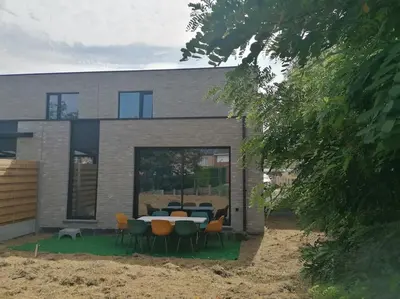a house with a table and chairs in front of it at Dunehill in Balen
