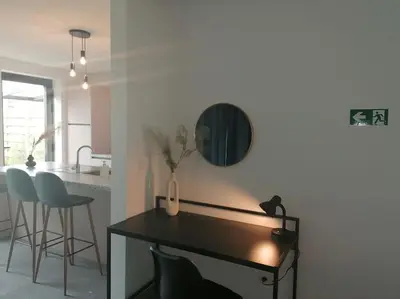 a kitchen with a table with a vase of flowers on it at Dunehill in Balen